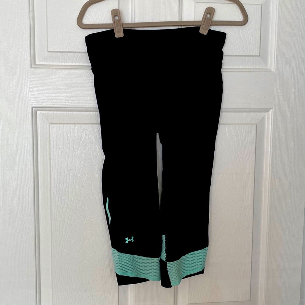 Black under-armour cropped leggings with mint mesh detail. Zipper pocket in back